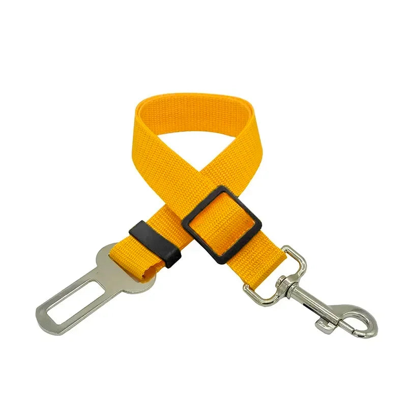Yellow adjustable pet seat belt with metal clip and buckle for car safety.